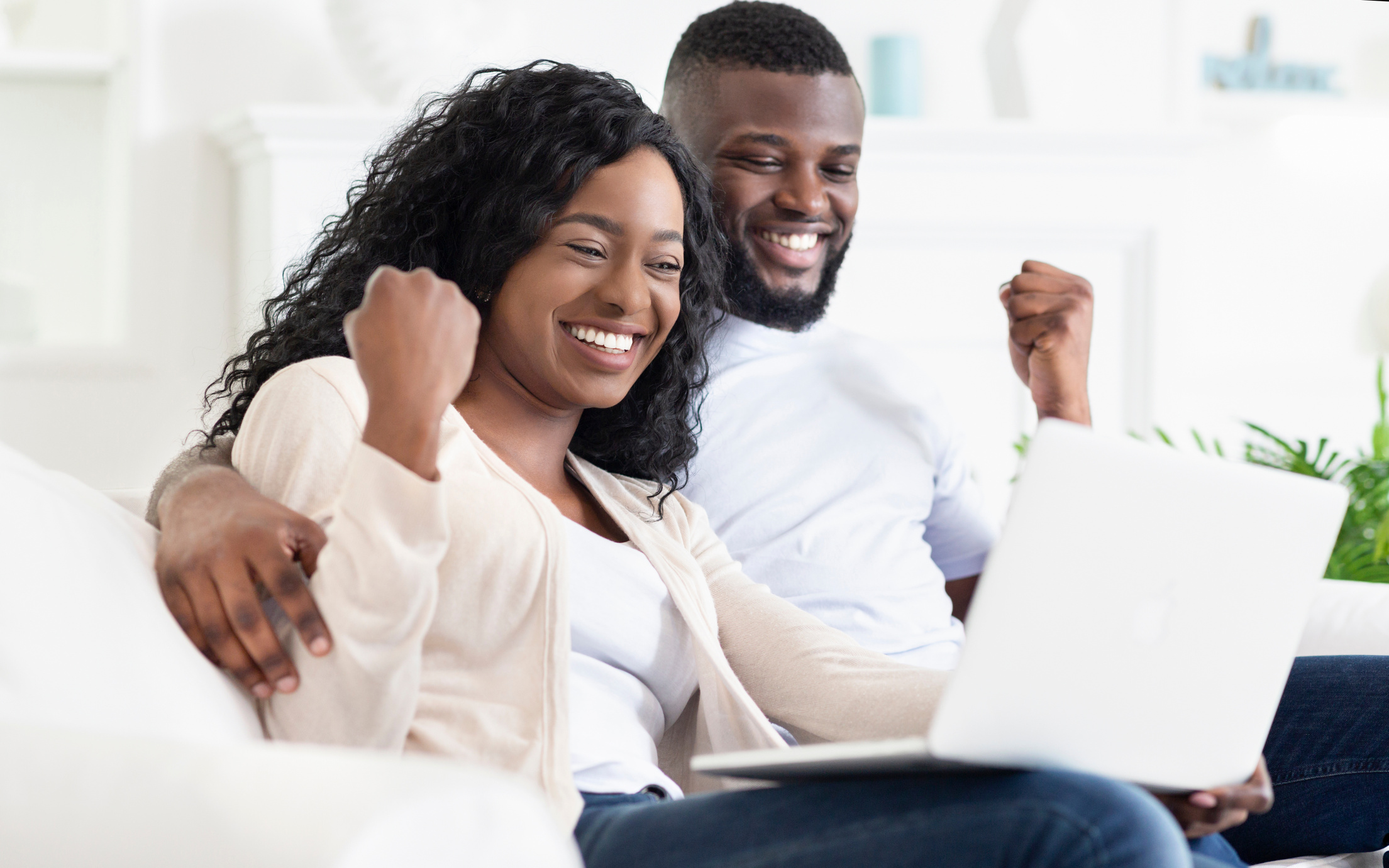 Excited Couple Looking at a Laptop 